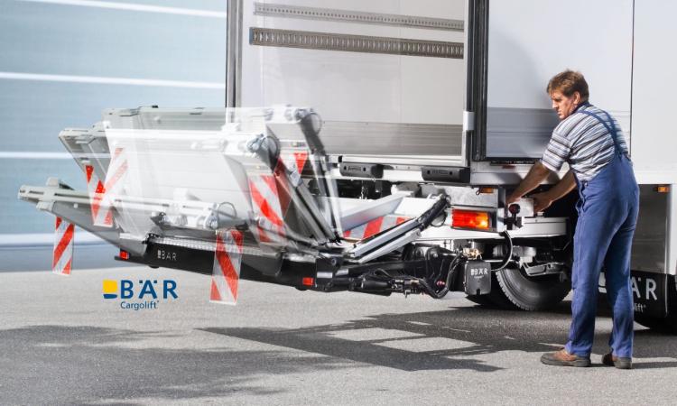 Operator rozkłada windę załadowczą Bar Cargolift HydFalt hydraulicznie za pomocą jednostki sterującej