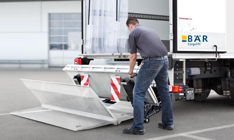 Operator rozkłada składaną windę załadowczą Bar Cargolift Falt